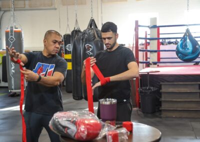 Two men in a gym with boxing gloves on